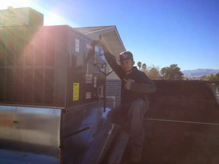 HVAC technician performing Air Duct Repair on a rooftop unit in Somerset