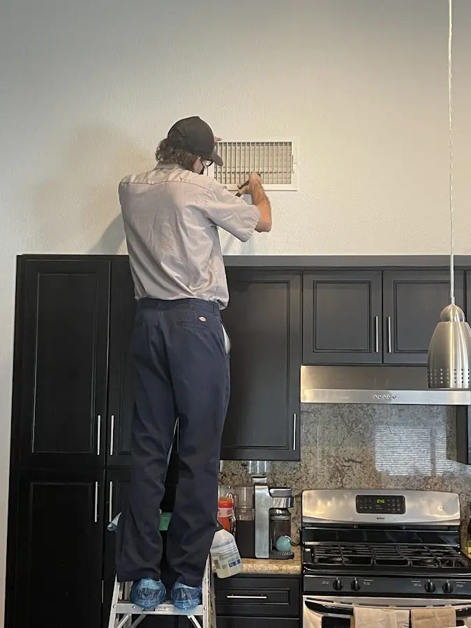 Technician inspecting an air vent during HVAC service in Somerset